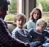 Mom, dad and two baby sons on a couch