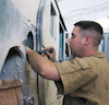 Military Man Inspecting Machinery